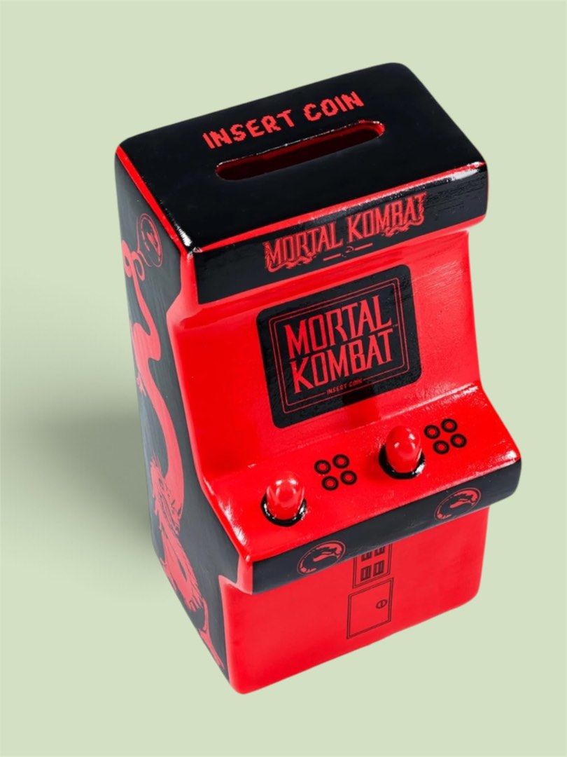 Mortal Kombat Arcade Coin Bank (Category: Figurines & Statues) located in Bacoor. Submitted by dangeusebio1515 (Listing ID 1460978905, Image 2). Description: - Mini Mortal Kombat arcade machine coin bank - Classic red and black design with dragon logo - 'Insert Coin' slot on top - Perfect for gamers and collectors - Fun way to save money.