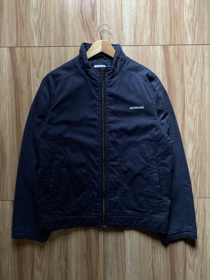 Moschino Jeans Navy Bomber Jacket (Category: Coats, Jackets and Outerwear) located in Pasig City. Submitted by dopedept_ (Listing ID 1461076089, Image 1). Description: - Navy Moschino Jeans bomber jacket - Classic zip-up style with stand-up collar - Two front pockets with button closures - Simple embroidered logo on the chest - Ideal for casual wear, pairs well with jeans or chinos.