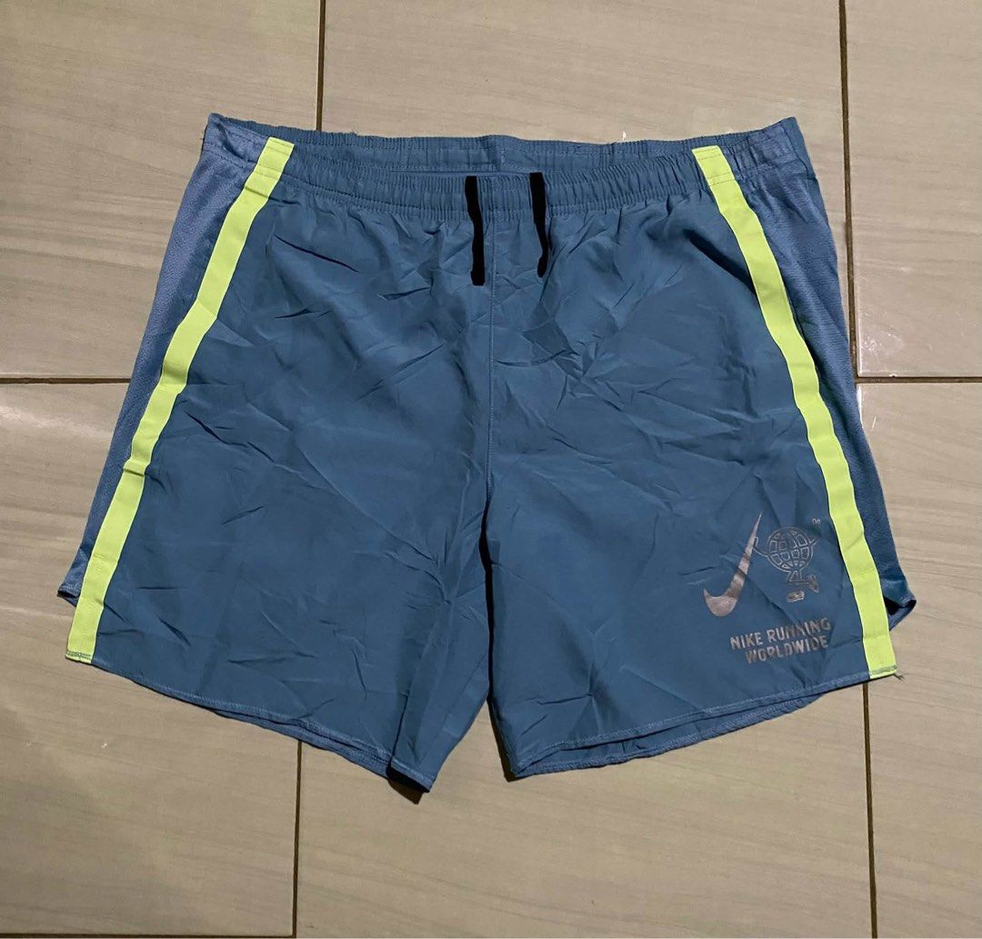 Nike Challenger Men's Running Shorts (Category: Shorts) located in San Carlos City. Submitted by roseee_012 (Listing ID 1461053340, Image 1). Description: - Blue Nike running shorts with neon yellow accents - Features the Nike Running Worldwide graphic - Elastic waistband with drawstring for a secure fit - Mesh panels on the sides for enhanced breathability - Back pocket for convenient storage of essentials - Ideal for your running sessions.