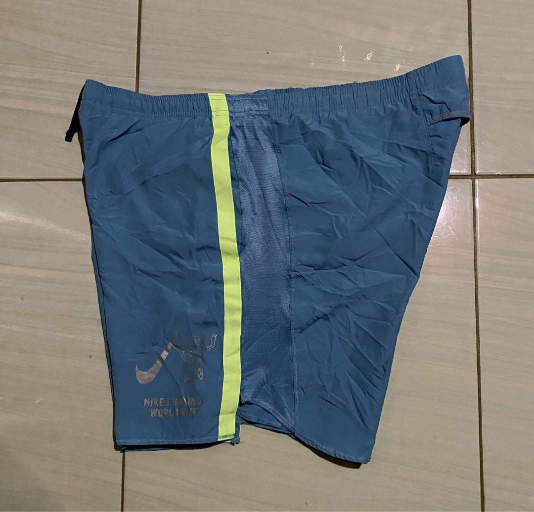 Nike Challenger Men's Running Shorts (Category: Shorts) located in San Carlos City. Submitted by roseee_012 (Listing ID 1461053340, Image 3). Description: - Blue Nike running shorts with neon yellow accents - Features the Nike Running Worldwide graphic - Elastic waistband with drawstring for a secure fit - Mesh panels on the sides for enhanced breathability - Back pocket for convenient storage of essentials - Ideal for your running sessions.