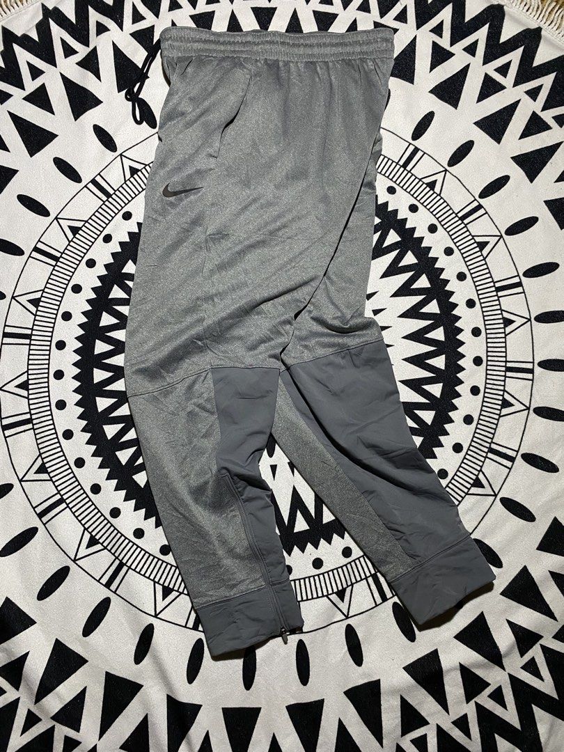 Nike Grey Athletic Track Pants Joggers Zip Cuffs (Category: Joggers) located in Badiangan. Submitted by iralorana.thrift (Listing ID 1461067017, Image 1). Description: - Grey Nike track pants - Elastic waistband with drawstring - Zipper closures at ankle cuffs - Two side pockets - Nike logo embroidered on left thigh - Ideal for workouts and casual wear.