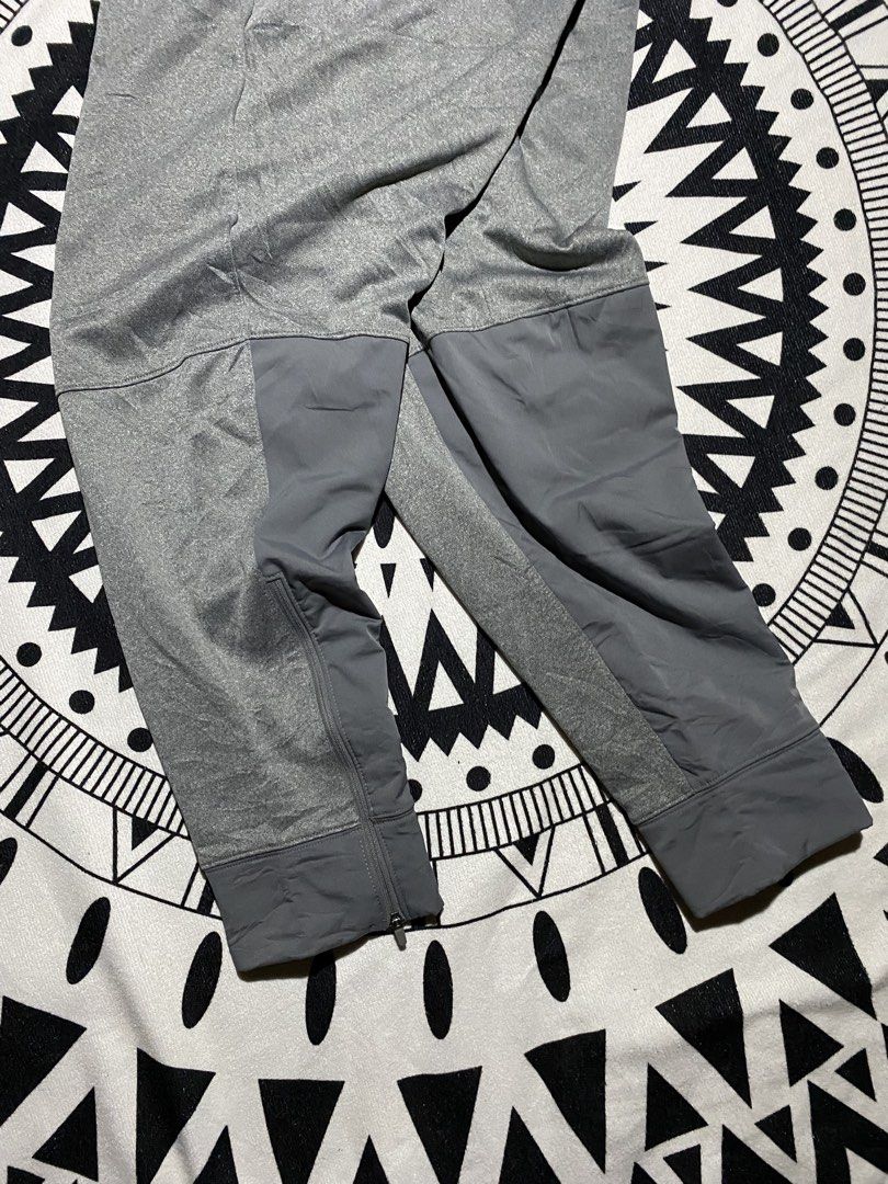 Nike Grey Athletic Track Pants Joggers Zip Cuffs (Category: Joggers) located in Badiangan. Submitted by iralorana.thrift (Listing ID 1461067017, Image 2). Description: - Grey Nike track pants - Elastic waistband with drawstring - Zipper closures at ankle cuffs - Two side pockets - Nike logo embroidered on left thigh - Ideal for workouts and casual wear.