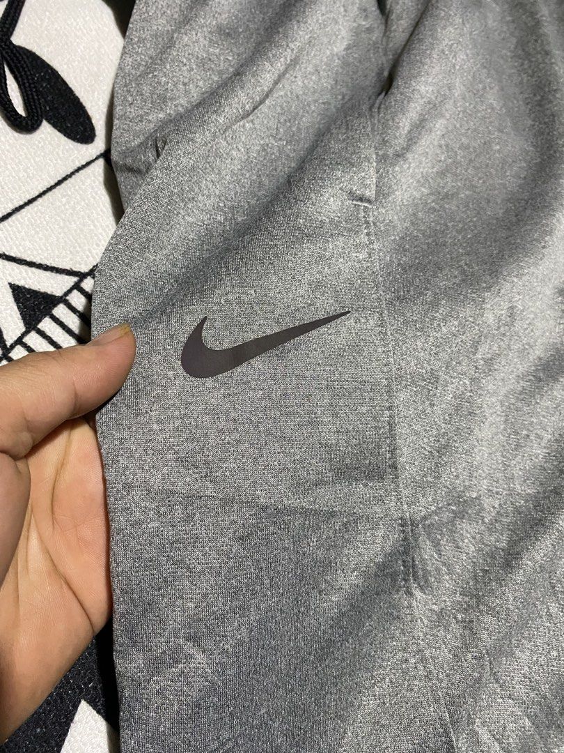 Nike Grey Athletic Track Pants Joggers Zip Cuffs (Category: Joggers) located in Badiangan. Submitted by iralorana.thrift (Listing ID 1461067017, Image 3). Description: - Grey Nike track pants - Elastic waistband with drawstring - Zipper closures at ankle cuffs - Two side pockets - Nike logo embroidered on left thigh - Ideal for workouts and casual wear.