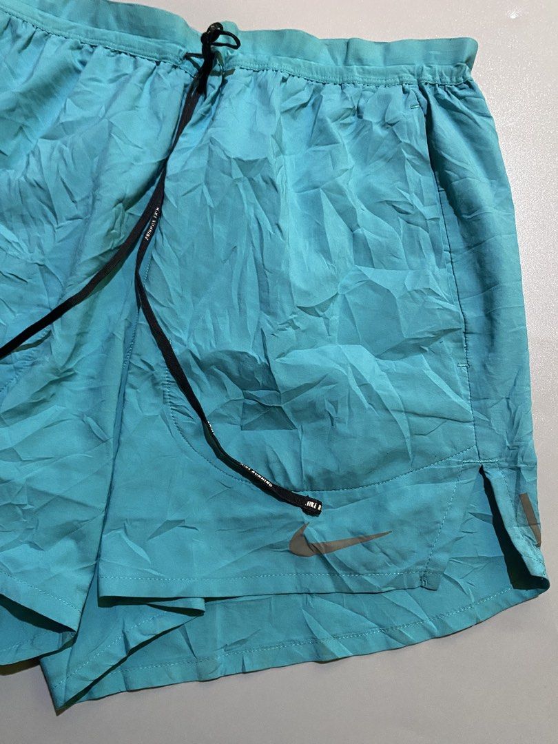 Nike Teal Running Shorts with Zip Pocket (Category: Activewear) located in Manila. Submitted by delunakenn94368 (Listing ID 1460925248, Image 3). Description: - Teal Nike running shorts - Elastic waistband with drawstring - Small zip pocket on the back - Nike logo on the leg - Lightweight material - Ideal for workouts or casual wear.