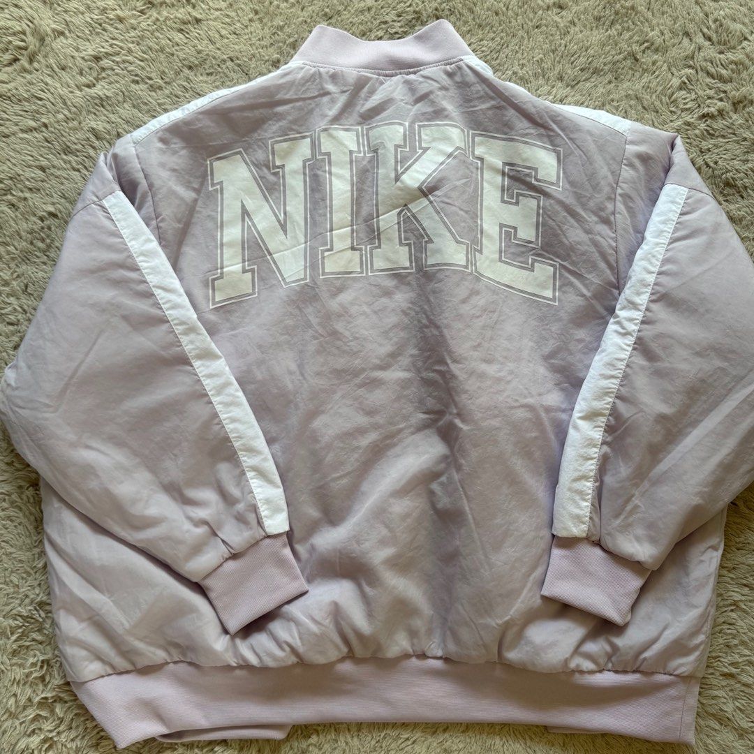 Nike Team Bomber Jacket Lilac Purple L (Category: Coats, Jackets and Outerwear) located in Taytay. Submitted by casaesguerra (Listing ID 1461007857, Image 3). Description: -used once only when we went to the states. - Lilac purple Nike bomber jacket - White stripe details on sleeves and collar - Large 'NIKE' graphic on the back - Button-up front - Features pockets - Ideal for casual wear 📍Taytay, Rizal Lalamove, grab, jnt, or Lbc express.