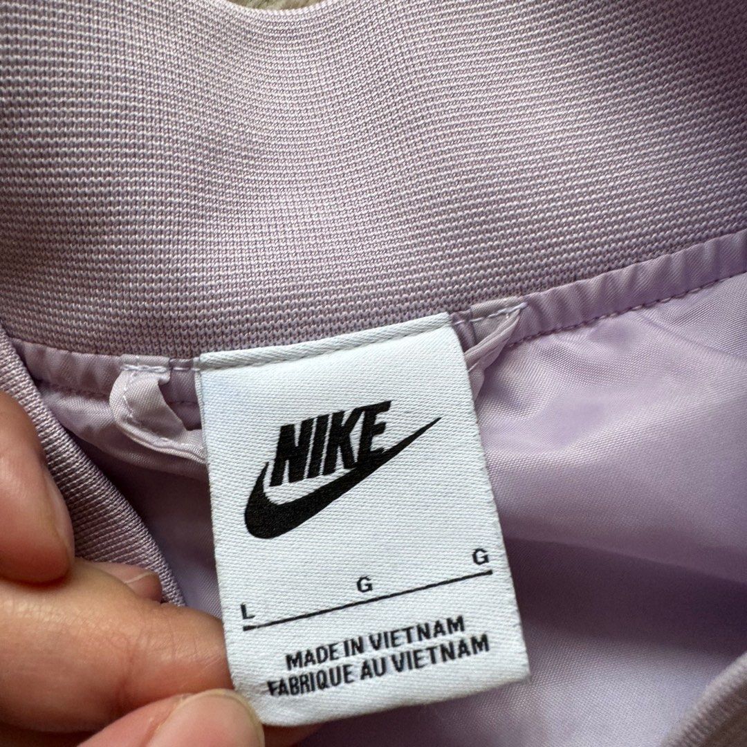 Nike Team Bomber Jacket Lilac Purple L (Category: Coats, Jackets and Outerwear) located in Taytay. Submitted by casaesguerra (Listing ID 1461007857, Image 2). Description: -used once only when we went to the states. - Lilac purple Nike bomber jacket - White stripe details on sleeves and collar - Large 'NIKE' graphic on the back - Button-up front - Features pockets - Ideal for casual wear 📍Taytay, Rizal Lalamove, grab, jnt, or Lbc express.