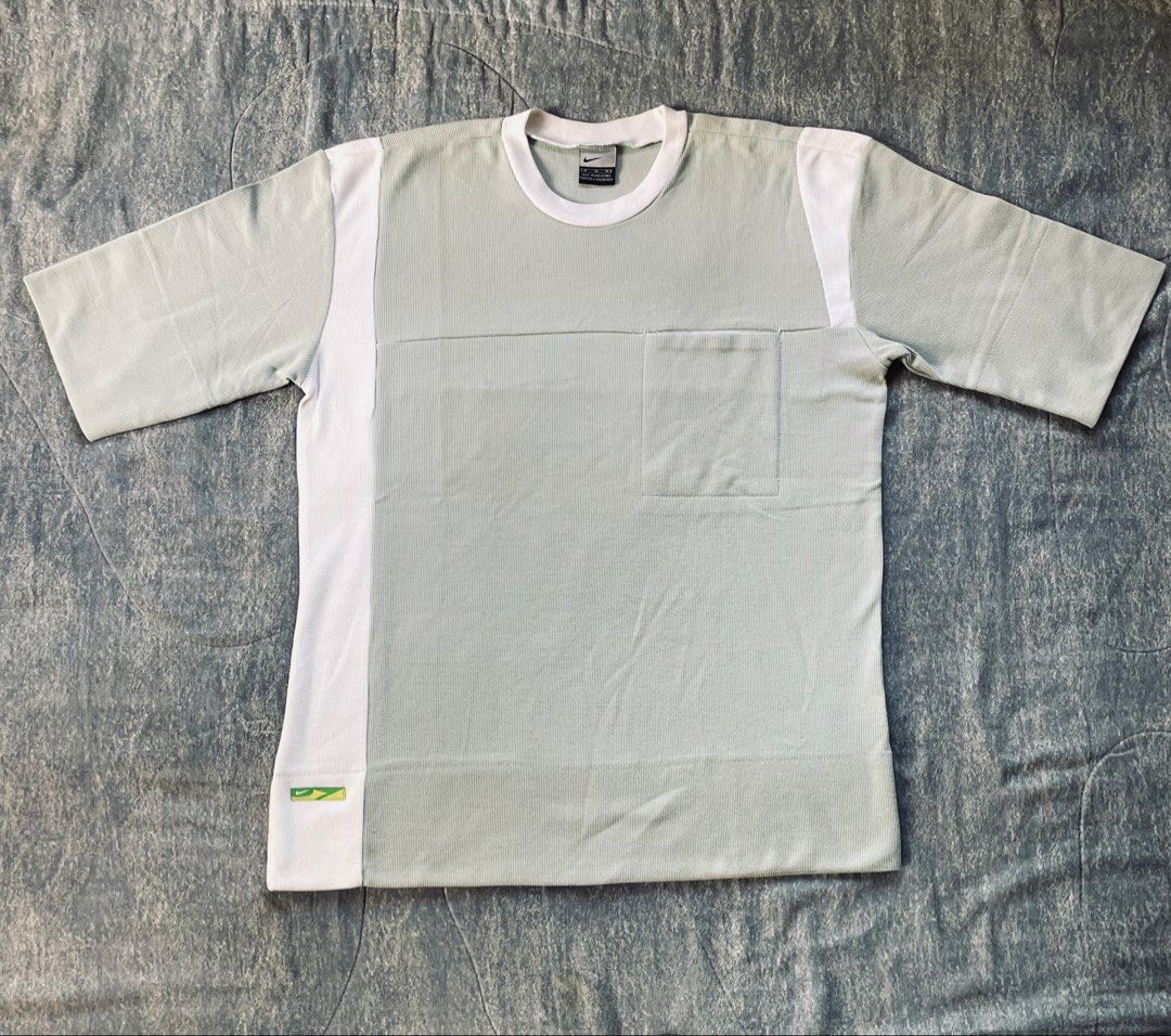 Nike T-Shirt Size M (Category: Tshirts & Polo Shirts ) located in Bato. Submitted by pandadada01 (Listing ID 1461018362, Image 2). Description: - Light grey Nike t-shirt - White accents on sides and sleeves - Features a chest pocket - Made in the Philippines - 100% Cotton material - Ideal for casual wear.