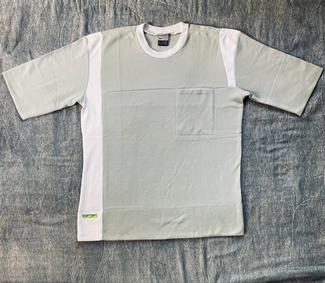 Nike T-Shirt Size M (Category: Tshirts & Polo Shirts ) located in Bato. Submitted by pandadada01 (Listing ID 1461018362, Image 1). Description: - Light grey Nike t-shirt - White accents on sides and sleeves - Features a chest pocket - Made in the Philippines - 100% Cotton material - Ideal for casual wear.