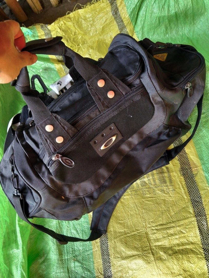 Oakley Software Black Duffle Bag (Category: Backpacks) located in Polomolok. Submitted by aldrex_18 (Listing ID 1461113827, Image 2). Description: - Authentic Oakley duffle bag - Ideal for travel or gym sessions - Multiple compartments and zippers for organized storage - Features Oakley logo, 'Factory Pilot', and 'Warning' patches - Adjustable straps for comfortable carrying.