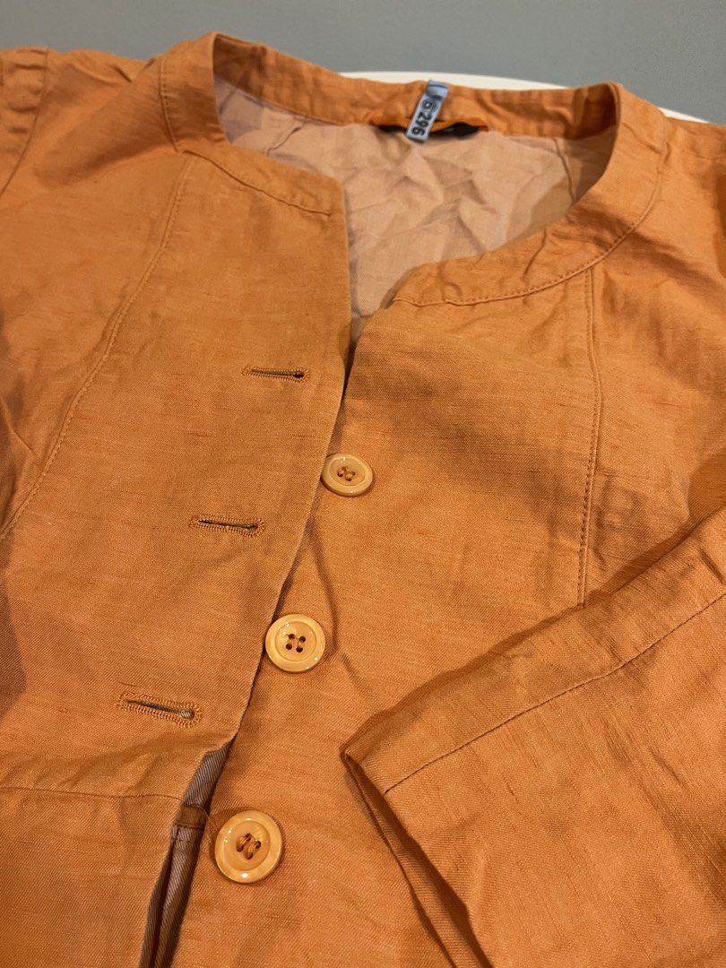 Orange Linen Blend Collarless Button-Up Jacket (Category: Coats, Jackets and Outerwear) located in Manila. Submitted by xoshushi.dcltr (Listing ID 1460973266, Image 3). Description: - Chic orange jacket with a comfortable linen-blend feel. - Stylish collarless design with a clean button-up front (3 visible buttons). - Flattering peplum hem for a feminine silhouette. - Versatile three-quarter sleeves featuring a unique patterned cuff lining. - Ide