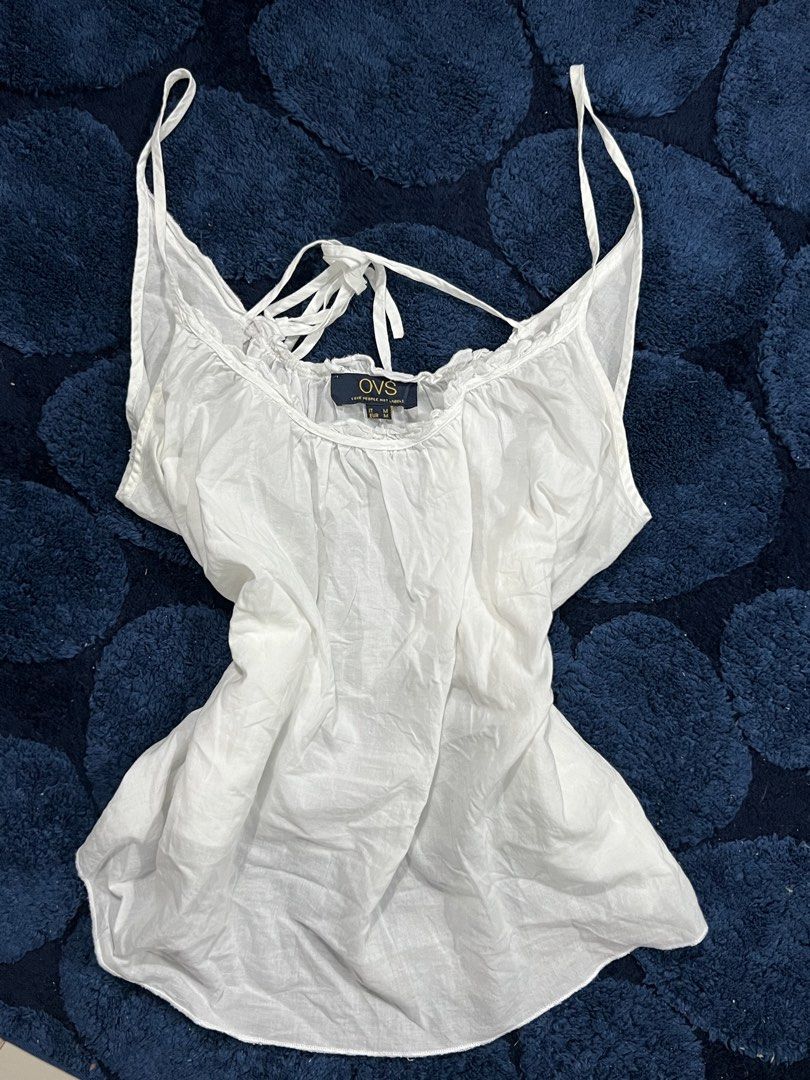 OVS White Spaghetti Strap Tank Top (Category: Sleeveless) located in Abucay. Submitted by pmuffy24 (Listing ID 1461102225, Image 1). Description: - White OVS tank top - Spaghetti straps with tie-back detail - Ruffled neckline - Lightweight fabric - Perfect for layering or wearing on its own - Easy to style.
