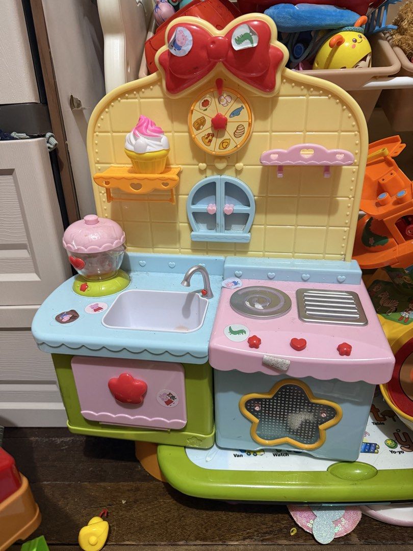 Toy Kitchen Playset with Accessories (Category: Kids Toys) located in San Juan City. Submitted by nnizel (Listing ID 1461052820, Image 2). Description: - Adorable Peppa Pig kitchen playset perfect for young children. - Features a sink, stove, and a cute cupcake accessory. - Includes fun details like a clock and shelves for added play value. - Encourages imaginative and creative play. - Some stickers are visible on the surfaces. Batter op working.