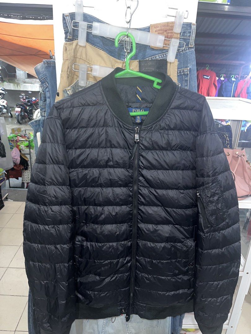 Polo Ralph Lauren Black Puffer Bomber Jacket (Category: Coats, Jackets and Outerwear) located in Tabuk. Submitted by collectors_thrift_shop (Listing ID 1461016849, Image 1). Description: - Polo puffer bomber jacket - Quilted design - Zip pockets - Ribbed collar and cuffs - Ideal for layering - Easy to pack and wear.