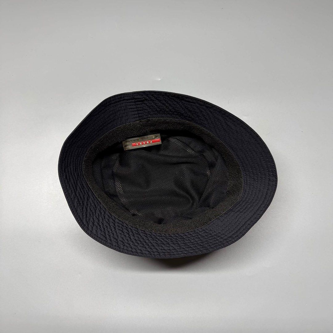 Prada Black Nylon Bucket Hat Red Logo Tag Size M (Category: Caps & Hats) located in Binalonan. Submitted by sheenaluxarchive (Listing ID 1460945217, Image 3). Description: - Authentic Prada Bucket Hat - Size: M - Material: 100% Acetate - Made in Italy - Iconic red Prada logo tag - Perfect for sunny weather - Please check photos for condition details.