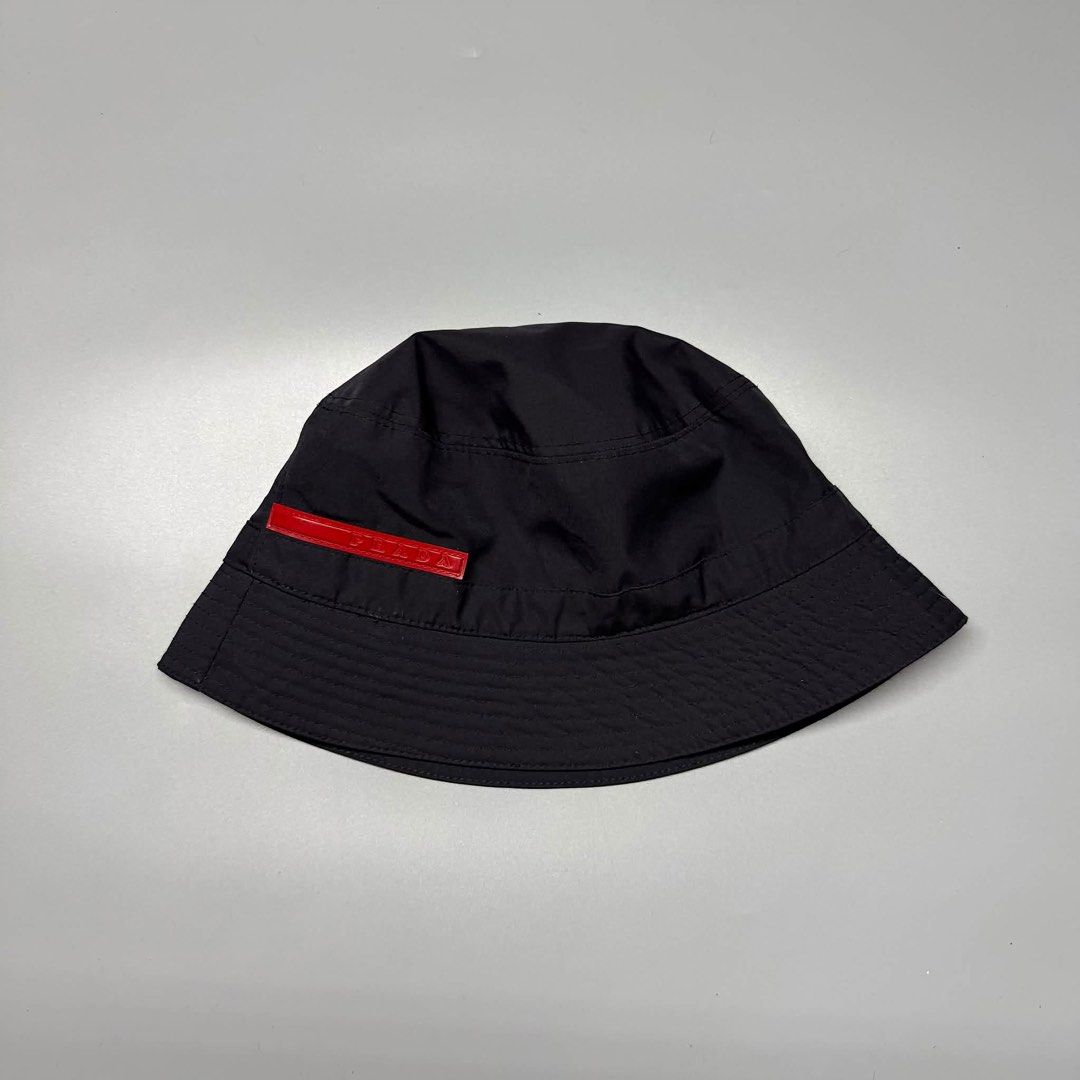 Prada Black Nylon Bucket Hat Red Logo Tag Size M (Category: Caps & Hats) located in Binalonan. Submitted by sheenaluxarchive (Listing ID 1460945217, Image 1). Description: - Authentic Prada Bucket Hat - Size: M - Material: 100% Acetate - Made in Italy - Iconic red Prada logo tag - Perfect for sunny weather - Please check photos for condition details.