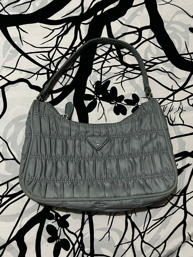 Prada Ruched Nylon Shoulder Bag (Category: Luxury Bags & Wallets) located in Infanta. Submitted by izzy2shop (Listing ID 1461113339, Image 1). Description: - Authentic Prada Bag - Color: Grey - Material: Ruched Nylon - Hardware: Silver - Closure: Zipper - Interior Details: 'Made in Italy' tag, '165' - Size: Small (ideal for essentials) - Style: Classic Prada.