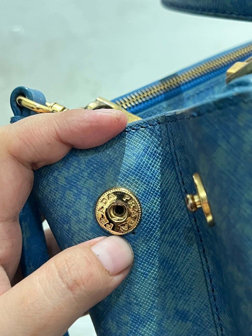 Prada Saffiano Lux Tote Bag Blue (Category: Luxury Bags & Wallets) located in Abucay. Submitted by chinithou (Listing ID 1460928086, Image 3). Description: - Prada bag - Color: Blue - Unique textured finish - Gold hardware details - Detachable shoulder strap included - Multiple interior compartments - Zippers and clasps in working condition - Versatile for everyday or special occasions.