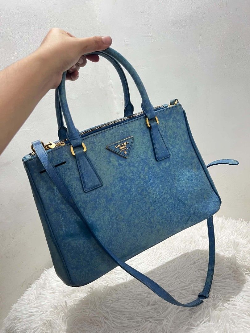 Prada Saffiano Lux Tote Bag Blue (Category: Luxury Bags & Wallets) located in Abucay. Submitted by chinithou (Listing ID 1460928086, Image 1). Description: - Prada bag - Color: Blue - Unique textured finish - Gold hardware details - Detachable shoulder strap included - Multiple interior compartments - Zippers and clasps in working condition - Versatile for everyday or special occasions.