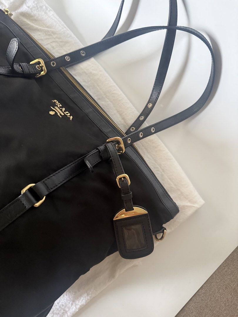 Prada Tessuto Nylon Tote Bag (Category: Luxury Bags & Wallets) located in Caloocan City. Submitted by krishazach (Listing ID 1461115170, Image 3). Description: - Authentic Prada tote bag - Color: Black nylon with black leather accents - Hardware: Gold - Features: Detachable shoulder strap, dust bag included - Interior: Spacious, ideal for daily essentials - Closure: Top zip Includes : Dust bag only Authentic 💯 See photos for issues 7/10.