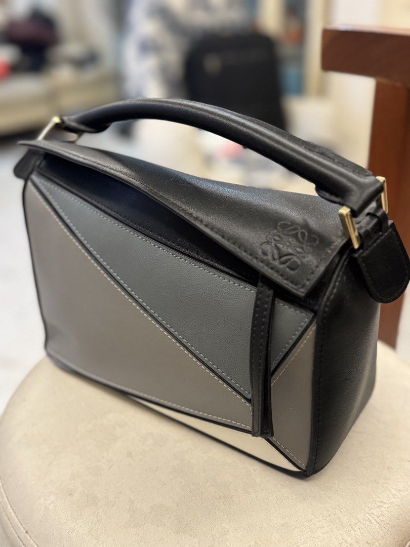 Puzzle Bag Black Grey White Leather (Category: Luxury Bags & Wallets) located in Bacolod City. Submitted by vintage_vogue6100 (Listing ID 1460998983, Image 3). Description: Color: Black, Grey, and White - Material: Genuine Leather - Features: Top handle and detachable shoulder strap - Closure: Zipper - Hardware: Gold-tone - Design: Iconic geometric pattern.