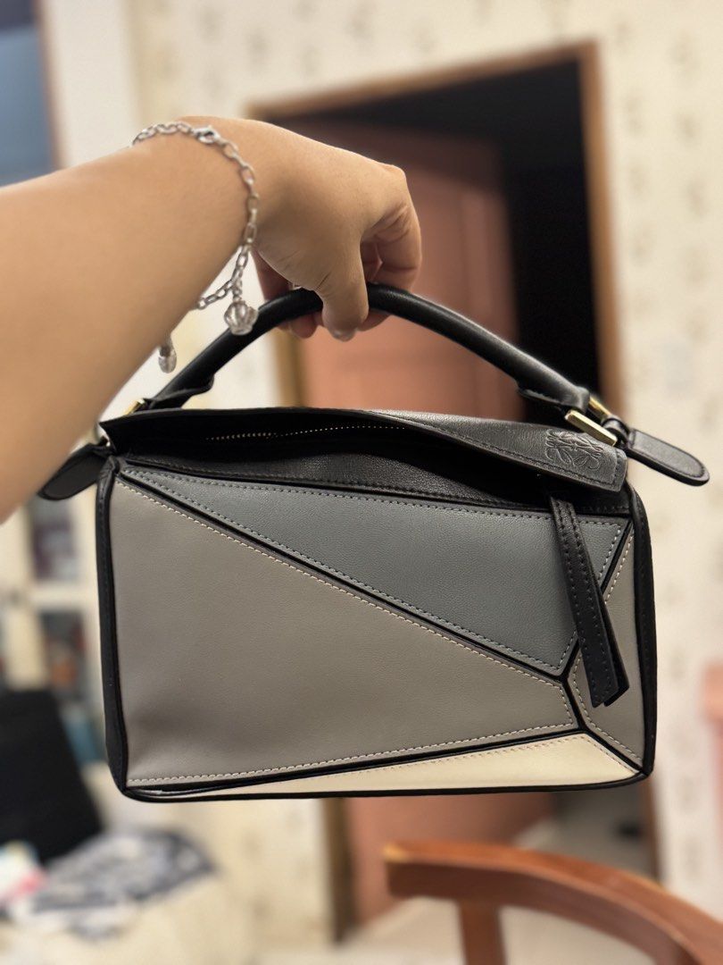 Puzzle Bag Black Grey White Leather (Category: Luxury Bags & Wallets) located in Bacolod City. Submitted by vintage_vogue6100 (Listing ID 1460998983, Image 2). Description: Color: Black, Grey, and White - Material: Genuine Leather - Features: Top handle and detachable shoulder strap - Closure: Zipper - Hardware: Gold-tone - Design: Iconic geometric pattern.