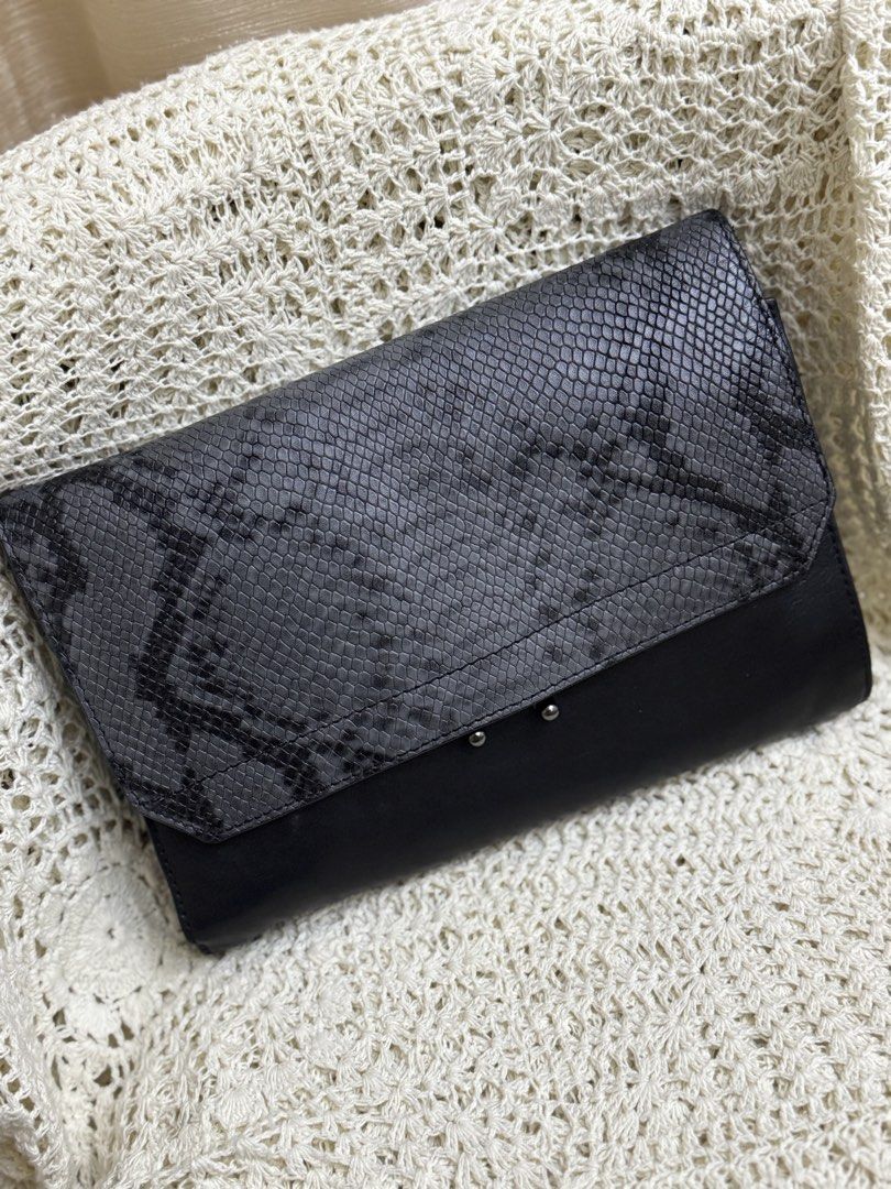 python-embossed foldover clutch / sling wallet (Category: Clutches) located in Bacolod City. Submitted by vintage_vogue6100 (Listing ID 1461040019, Image 3). Description: - python-embossed foldover clutch / sling wallet - Stylish black leather clutch - Eye-catching grey snake print flap - Secure magnetic closure with a small metal clasp - Multiple interior compartments and zippered pockets - Includes a detachable shoulder strap for versatility - 
