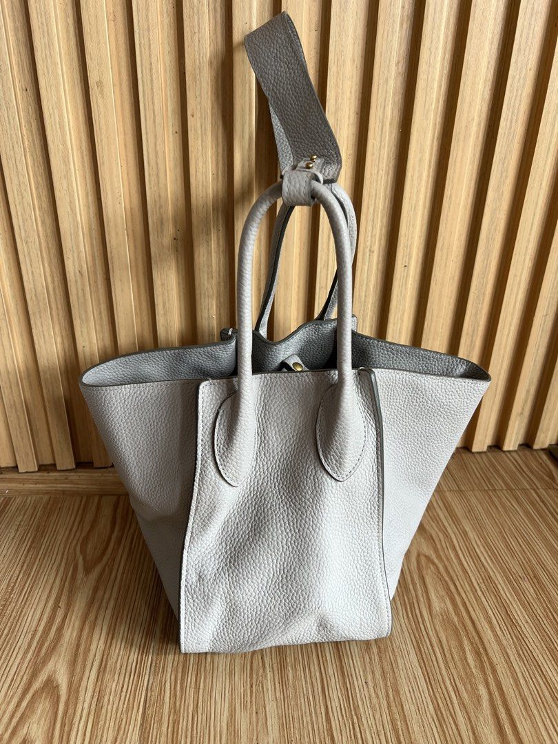 Rabeanco Wings Style Medium Cowhide Leather Bag (Category: Tote Bags) located in Lipa City. Submitted by thyra06 (Listing ID 1460931968, Image 1). Description: - Stylish grey leather tote bag - Medium size - Versatile: can be worn as a shoulder bag or crossbody - Interior features a zip pocket and a slip pocket - Elegant gold-toned hardware - Structured base with protective feet - Ideal for carrying daily essentials.