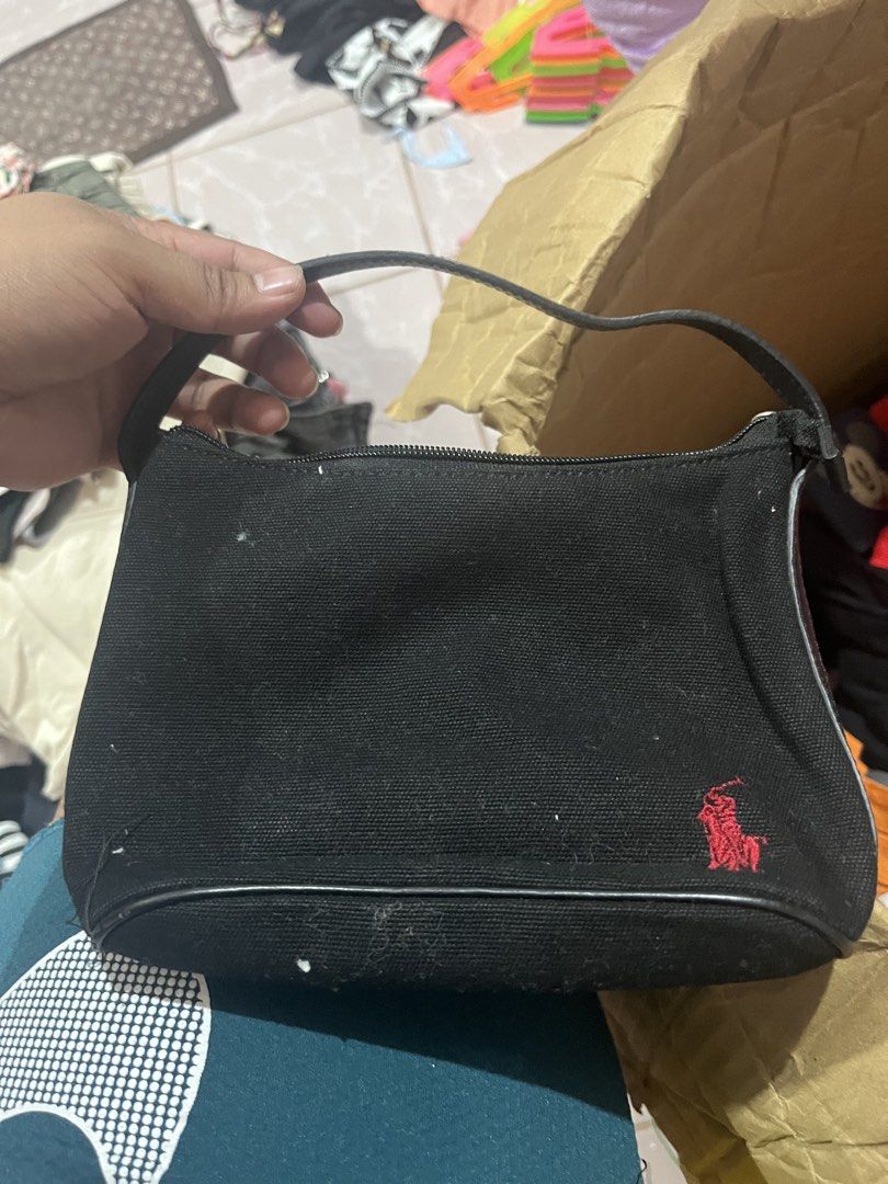 Ralph Lauren Black Canvas Mini Shoulder Bag (Category: Luxury Bags & Wallets) located in Tabuk. Submitted by collectors_thrift_shop (Listing ID 1461017439, Image 3). Description: - Cute black canvas shoulder bag from Ralph Lauren - Features the iconic red polo player logo - Small size, perfect for carrying essentials - Secure zipper closure - Interior slip pocket for organization - Adjustable strap for comfortable wear - Great for casual outings 
