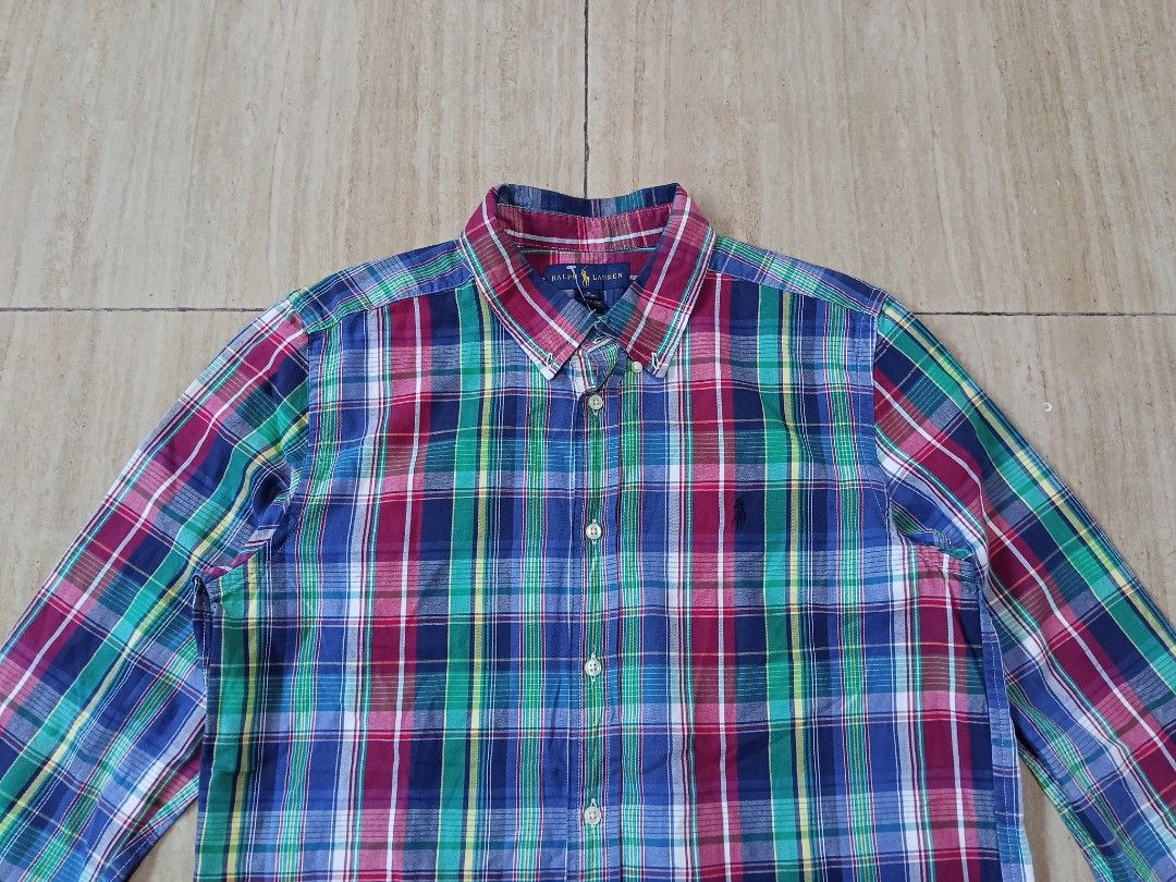 Ralph Lauren Plaid Button Down Shirt (Category: Tshirts & Polo Shirts ) located in Glan. Submitted by cpaharodde48008 (Listing ID 1460961847, Image 3). Description: - Classic Ralph Lauren plaid button-down shirt - Features a colorful pattern with blue, green, and red - Made of 100% soft cotton - Button closure and long sleeves - Perfect for casual wear or as a layering piece.