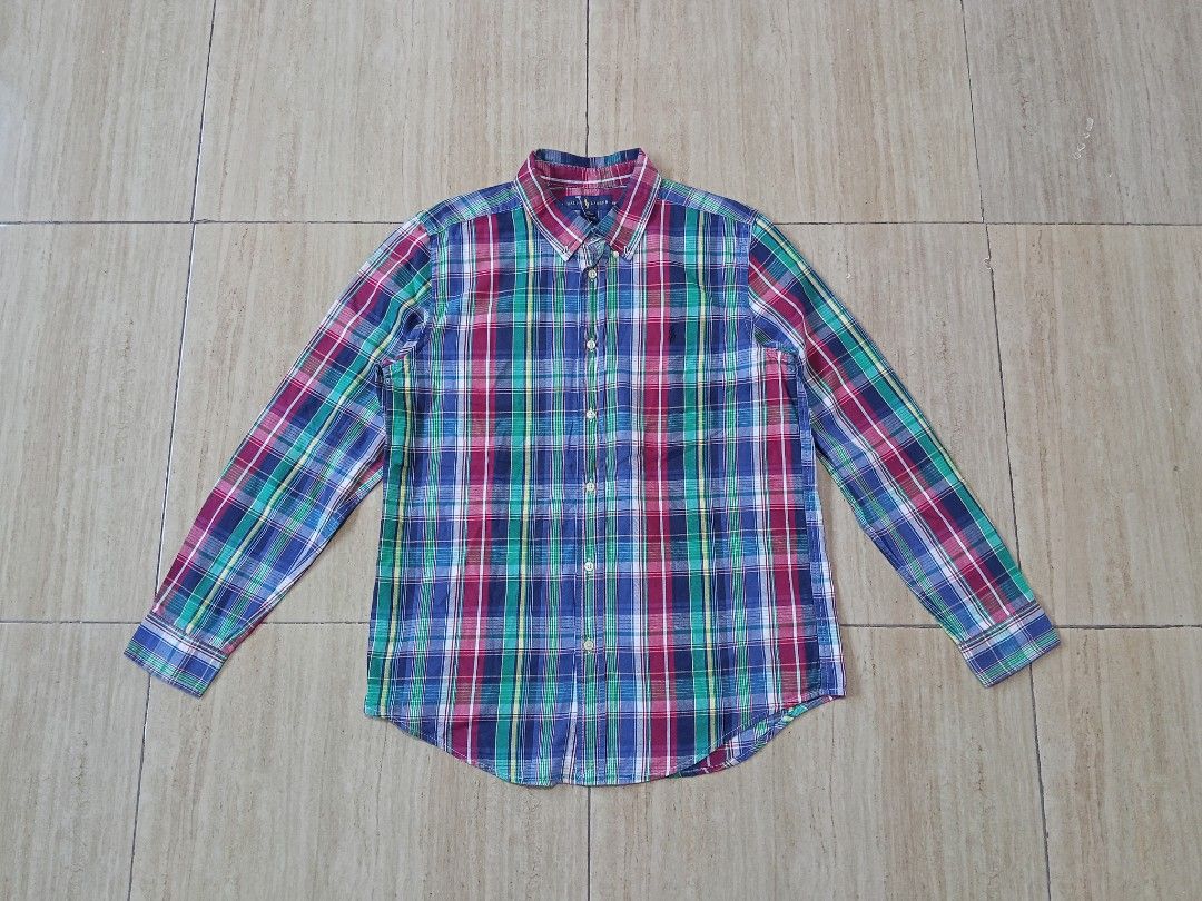 Ralph Lauren Plaid Button Down Shirt (Category: Tshirts & Polo Shirts ) located in Glan. Submitted by cpaharodde48008 (Listing ID 1460961847, Image 1). Description: - Classic Ralph Lauren plaid button-down shirt - Features a colorful pattern with blue, green, and red - Made of 100% soft cotton - Button closure and long sleeves - Perfect for casual wear or as a layering piece.