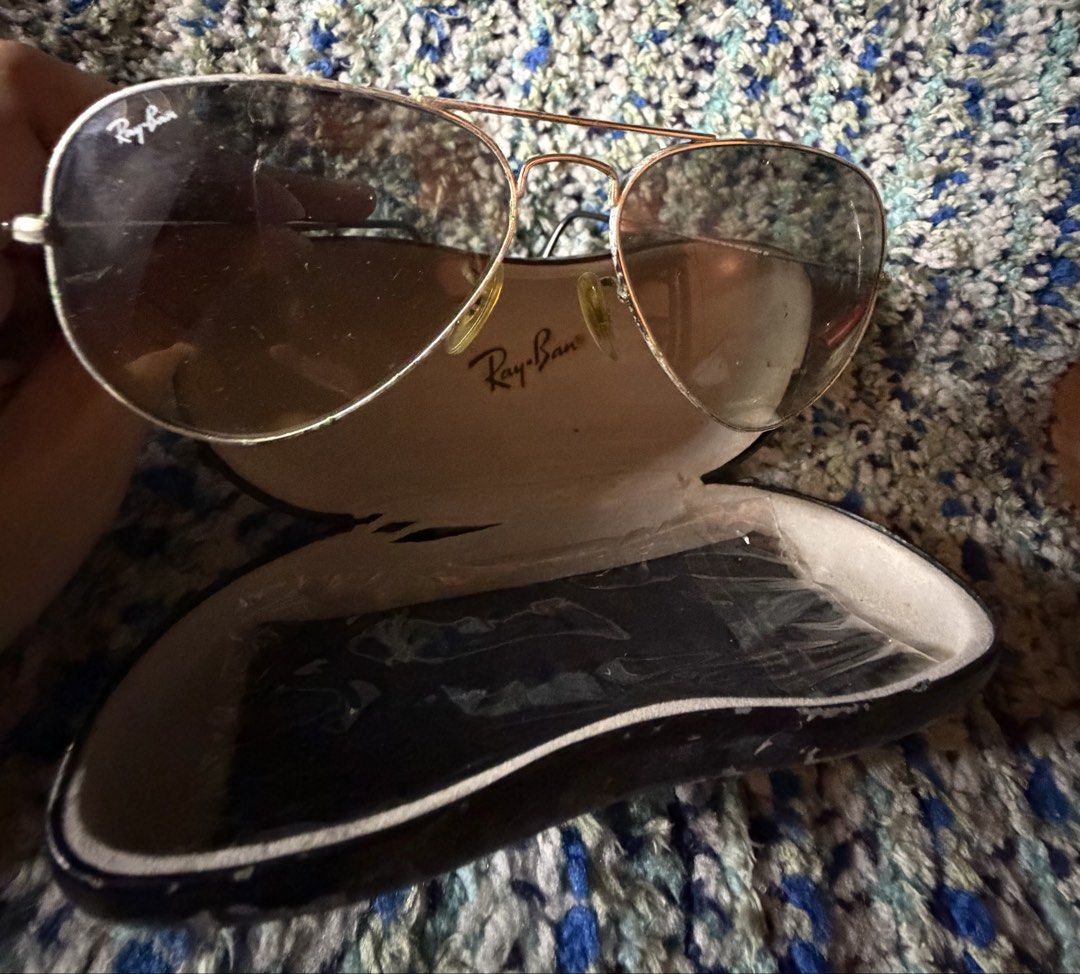 Ray-Ban Aviator Sunglasses with Case (Category: Sunglasses & Eyewear) located in Quezon City. Submitted by jhosa888 (Listing ID 1461051531, Image 3). Description: - Classic Ray-Ban aviator sunglasses - Gold frame with tinted lenses - Includes original Ray-Ban hard case - Perfect for sunny days - Lenses have some smudges - Case shows some wear inside.