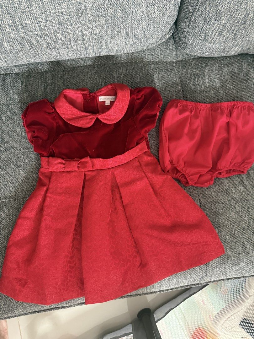 Red Baby Formal Dress - Periwinkle (Category: Babies & Kids Fashion) located in Las Pinas. Submitted by whistlesnowbells (Listing ID 1460965513, Image 1). Description: Used once for an occasion Brand: Periwinkle - Size: 6 months. - Dress features a luxurious velvet top and a brocade skirt with a subtle pattern. - Elegant Peter Pan collar and a sweet bow detail at the waist. - Convenient closure with small pearl buttons at the back. - Ideal for pa