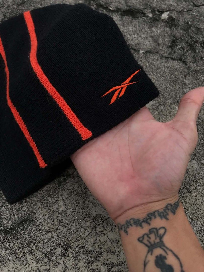 Reebok Black Beanie with Red Stripes (Category: Caps & Hats) located in Davao. Submitted by waloohpuf (Listing ID 1460925159, Image 2). Description: - Classic black Reebok beanie - Features two bold red stripes on the front - Embroidered Reebok vector logo on the side - Made from comfortable knit material - Ideal for staying warm in cooler weather - Simple and stylish design.