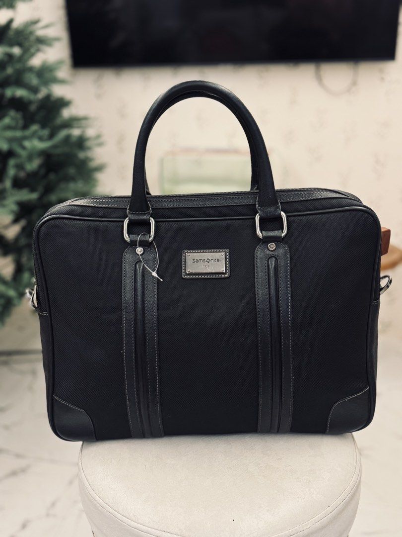 Samsonite Black Business Briefcase Bag (Category: Briefcases) located in Bacolod City. Submitted by vintage_vogue6100 (Listing ID 1461070666, Image 2). Description: - Classic black briefcase - Durable material with leather accents - Features top handles and a detachable shoulder strap - Offers plenty of space for your work essentials - Ideal for daily commutes and business trips.