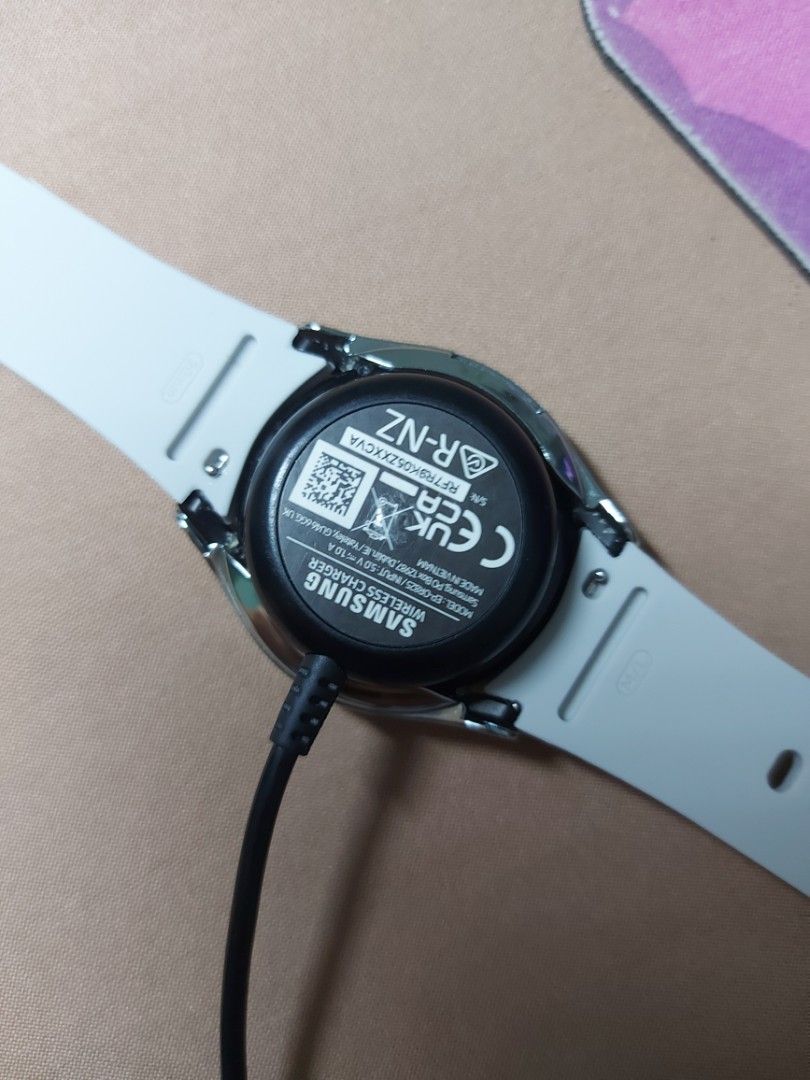 Samsung Galaxy Watch 4 40mm Smartwatch (Category: Wearables & Smart Watches) located in Manila. Submitted by nicolezald25729 (Listing ID 1461018735, Image 3). Description: - Samsung Galaxy Watch 4 - 40mm size - Includes original light grey strap - Currently charging, displaying a cute animated watch face - Back shows model details and charging port -Inclusions: Watch Accesories and chord charger only Loc: Parañaque.