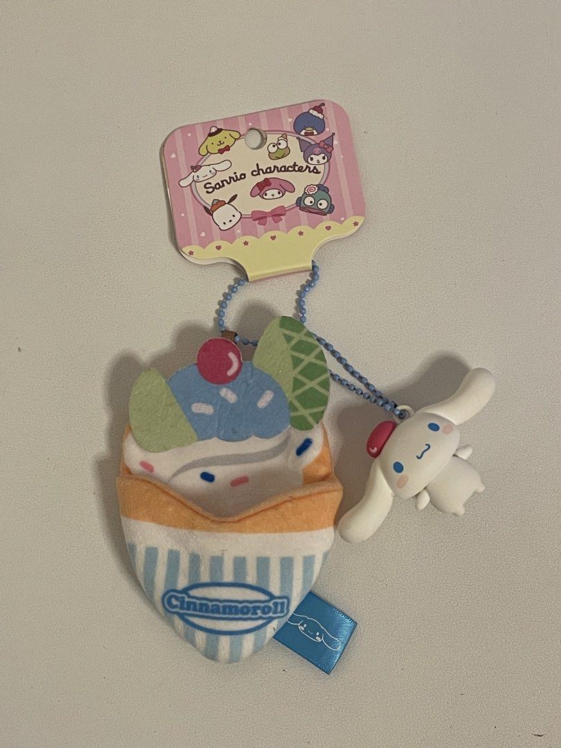 Sanrio Cinnamoroll Cupcake Plush Keychain (Category: Plushies & Soft Toys) located in Iba. Submitted by wealtheallymari99 (Listing ID 1461084452, Image 3). Description: - Adorable Cinnamoroll plush keychain designed as a cupcake. - Features Cinnamoroll peeking out from the top. - Comes with a stylish blue beaded chain. - Includes a cute blue ribbon tag. - Perfect for personalizing bags, backpacks, and more. - Authentic Sanrio merchandise..