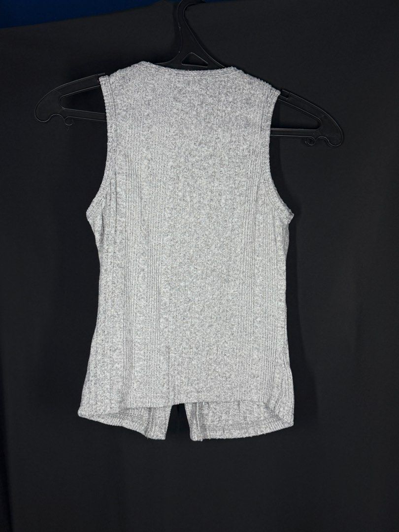 SHEIN Grey Ribbed Button-Up Sleeveless Tank Top (Category: Sleeveless) located in Angeles City. Submitted by lesmiz24601 (Listing ID 1460975169, Image 2). Description: - Grey ribbed tank top from SHEIN - Sleeveless design - Button-up front - Split hem detail - Estimated size S/M - Versatile for layering or standalone wear.