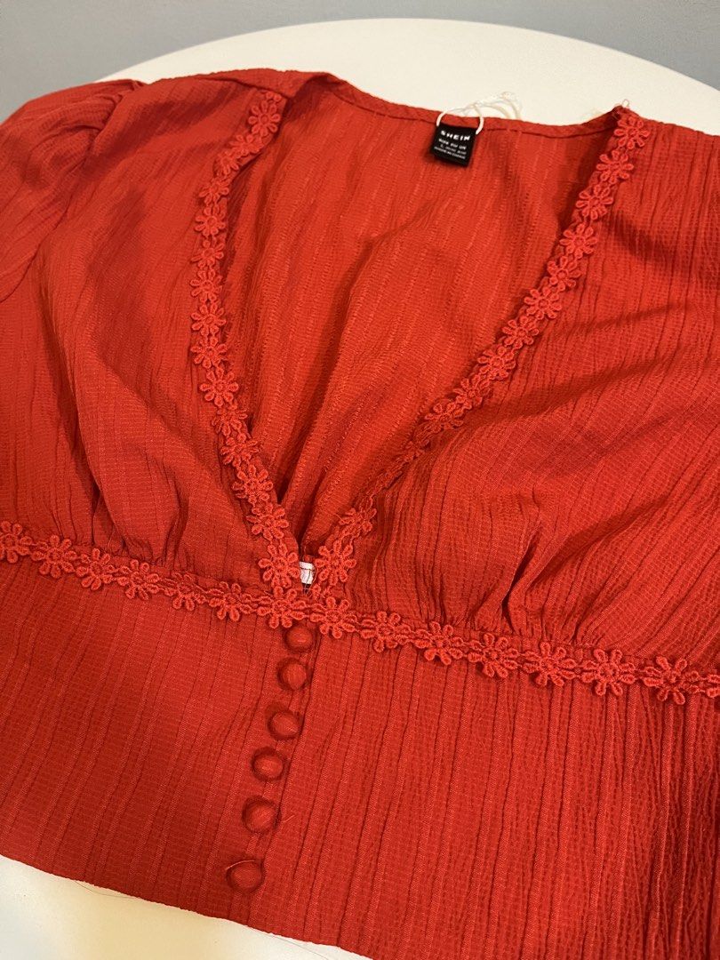 SHEIN Red Button Front Cropped Top with Lace Trim (Category: Blouses) located in Manila. Submitted by xoshushi.dcltr (Listing ID 1460976702, Image 3). Description: - Red cropped top from SHEIN - Size: L - V-neck with floral lace trim - Button-up front - Puff sleeves - Textured fabric - Versatile for casual or dressed-up looks.