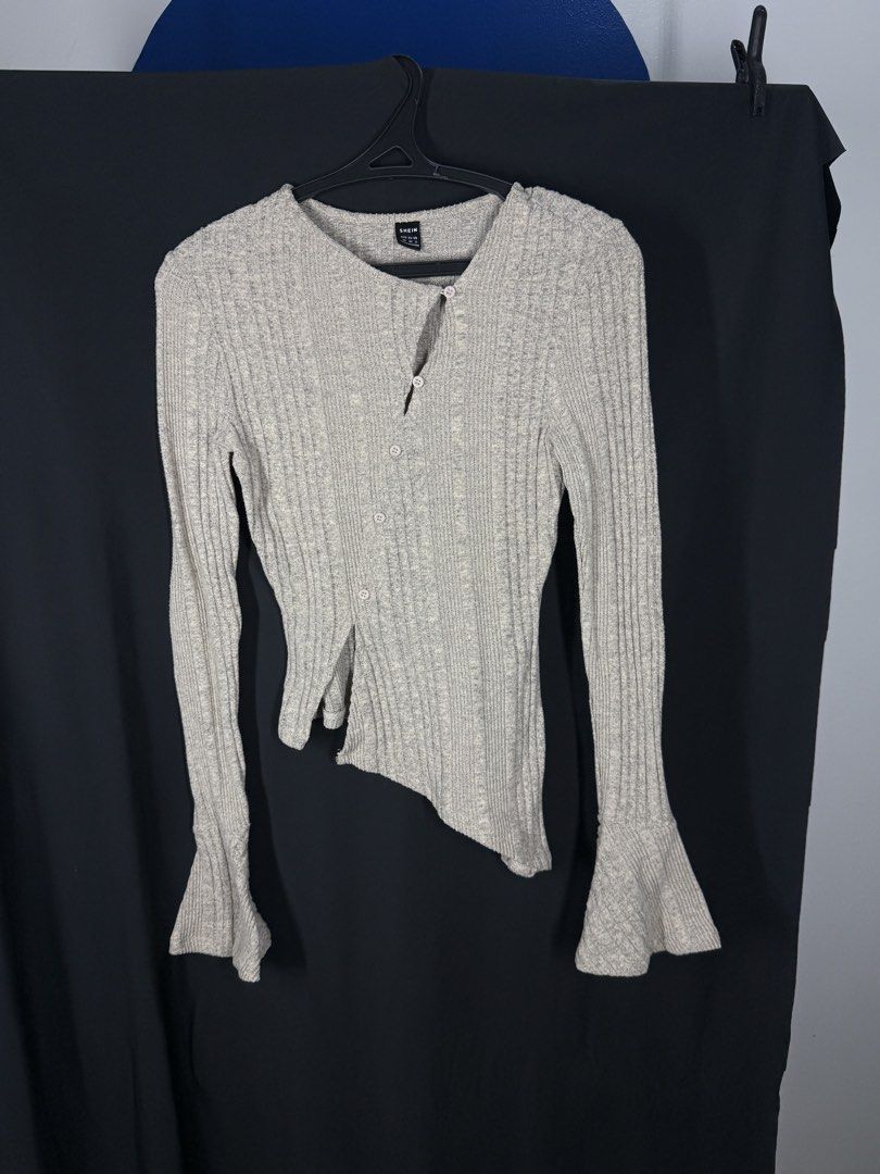 SHEIN Ribbed Bell Sleeve Asymmetrical Button Up Top (Category: Longsleeves) located in Angeles City. Submitted by lesmiz24601 (Listing ID 1460975091, Image 1). Description: - Light grey ribbed top from SHEIN - Long sleeves with unique bell cuffs - Asymmetrical hemline with button details down the front - Very unique and versatile design - Perfect for dressing up or down.