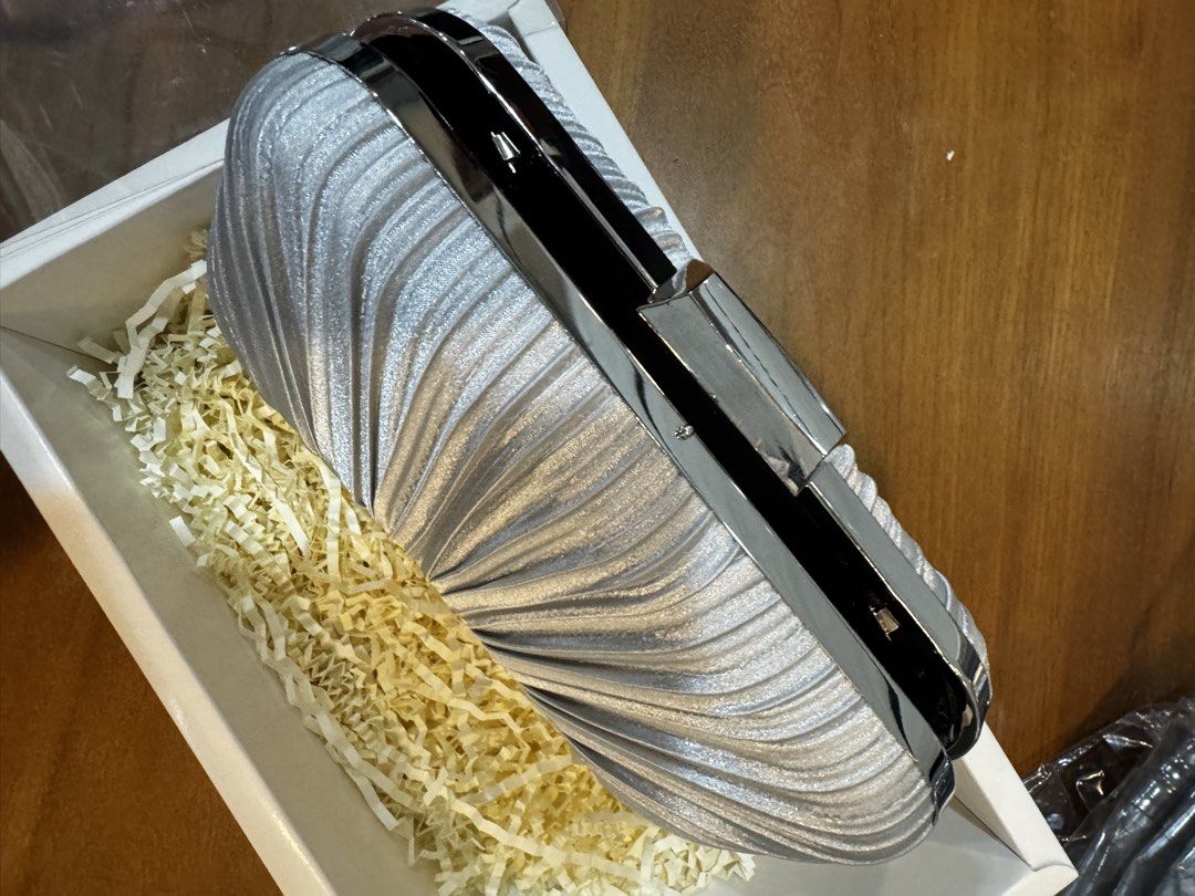 Silver Pleated Clutch Bag with Chain (Category: Clutches) located in Manila. Submitted by goodthingspreloved.92 (Listing ID 1461014594, Image 2). Description: - Stunning silver pleated clutch bag - Secure and sleek metal clasp closure - Luxurious black satin lining inside - Includes a detachable silver chain strap - Ideal for parties, weddings, and formal occasions.