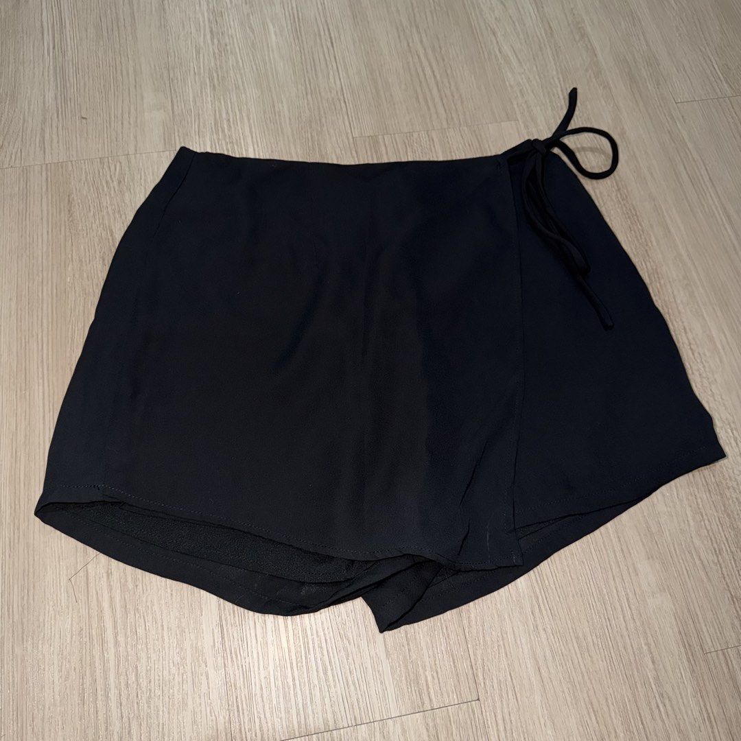 Something Borrowed Black Wrap Skort (Category: Shorts) located in Manila. Submitted by sg.21 (Listing ID 1461055890, Image 1). Description: - Black wrap skort from Something Borrowed - Features a tie detail on the side - Zipper closure at the back - Skirt appearance with shorts underneath for comfort and practicality - Perfect for casual outings Waist 13” Length 12”.