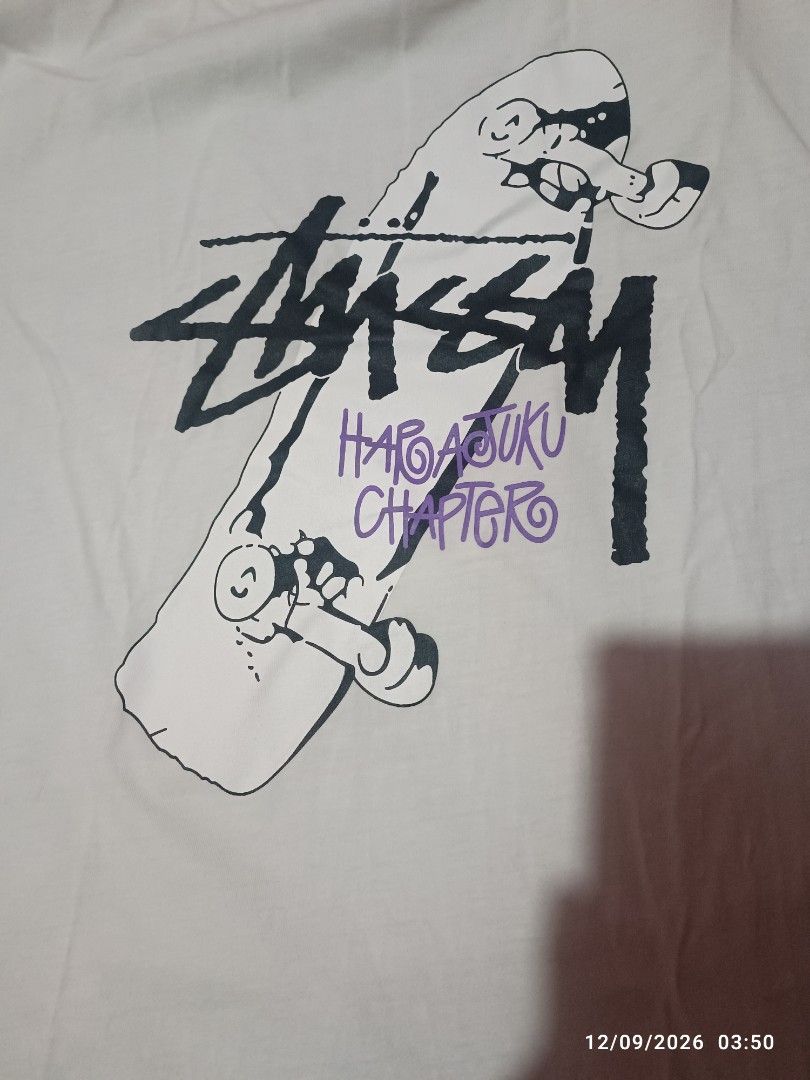 Stussy Chapter Tee (Category: Tshirts & Polo Shirts ) located in Pasig City. Submitted by 9tsu6 (Listing ID 1461109604, Image 2). Description: - White Stussy T-shirt - Size: Large (L) 20 x 28 - Graphic Print: Stussy logo, skateboard design, and 'Harajuku Chapter' text - Material: 100% Cotton - Style: Casual wear Walang basag; needs wash Nagka stain na blue, Authentic po Delivery or Meetup SM Megamall.
