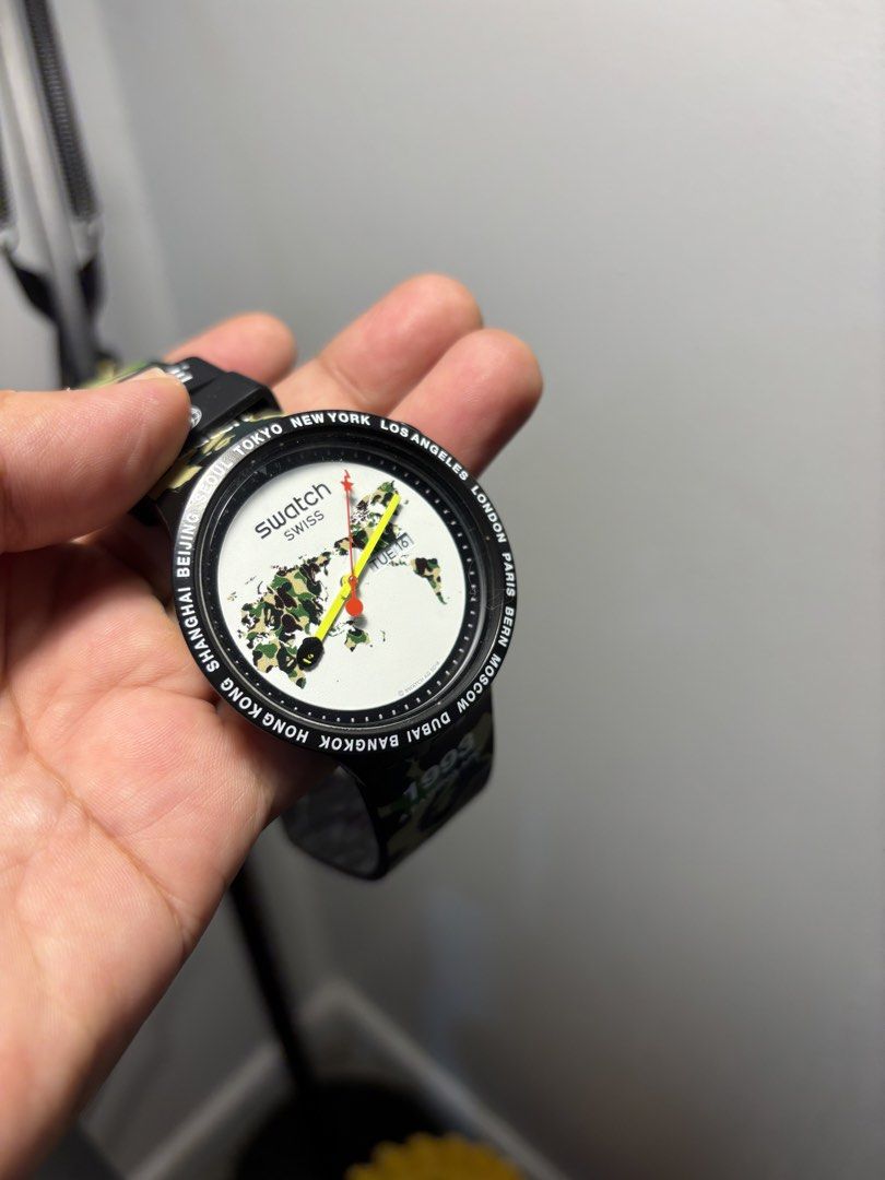 Swatch x BAPE 1993 World Map Camo Watch (Category: Men's Watches) located in Pasig City. Submitted by akosidarius (Listing ID 1461067036, Image 2). Description: - Authentic Swatch x BAPE collaboration watch. - Unique world map dial with city names on the bezel. - Stylish camouflage strap with BAPE branding. - Back features Swatch logo and '1993' inscription. - A must-have collectible for fans and watch enthusiasts..