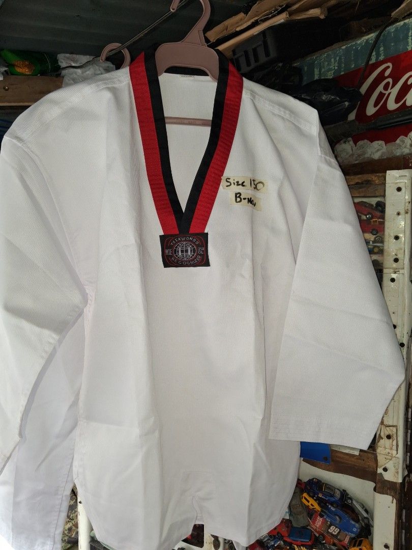 Taekwondo Dobok Uniform Size 150 (Category: Combat Sports) located in Manila. Submitted by marcas022798212 (Listing ID 1460990140, Image 1). Description: - White Taekwondo dobok - Size: 150 - Red and black trim on collar - 'WTF TAEKWONDO RECOGNIZED' patch included - Label indicates 'B-New' (Brand New) - Made in China - Ideal for Taekwondo training.