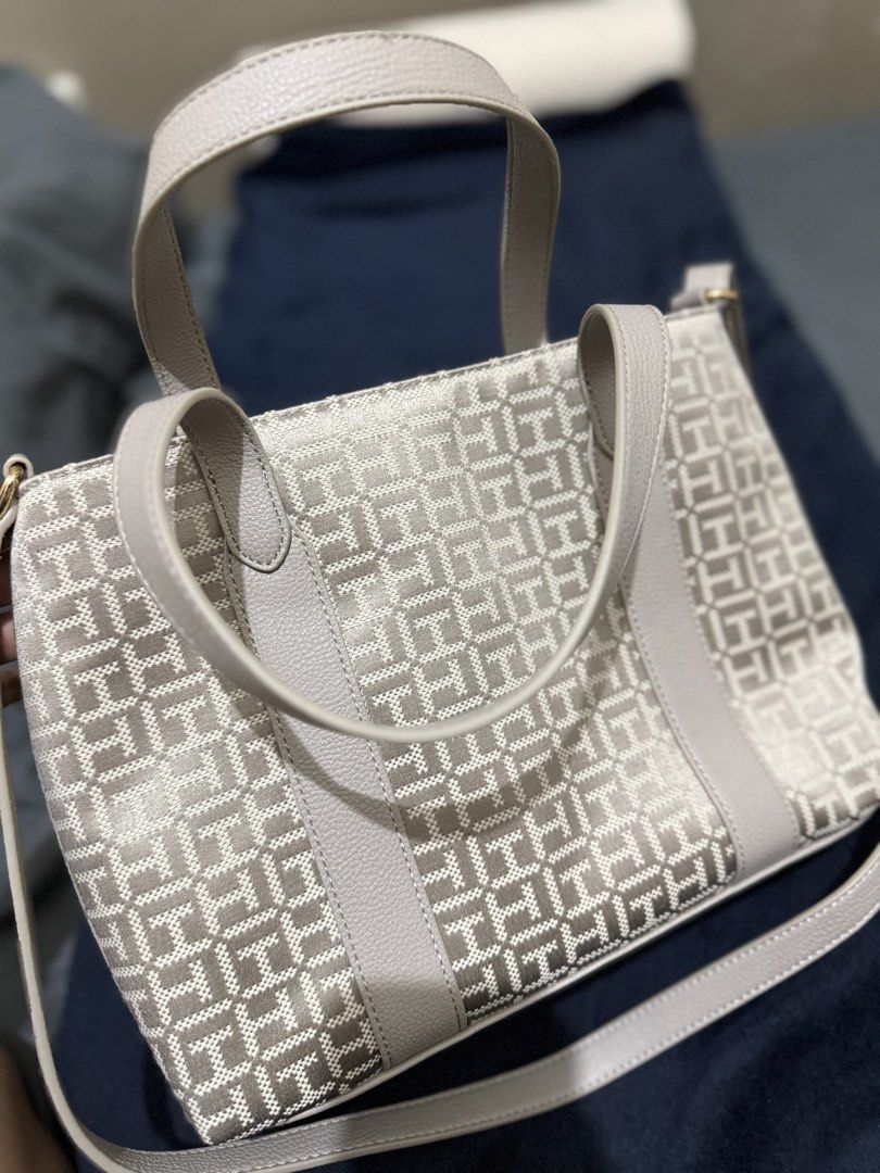 Tommy Hilfiger Monogram Tote Bag (Category: Tote Bags) located in Batangas. Submitted by cathevans (Listing ID 1460977605, Image 3). Description: - Authentic Tommy Hilfiger tote bag - Signature monogram pattern - Light grey trim and handles - Interior zippered compartment and slip pockets - Gold hardware detail on the front - Comes with a detachable shoulder strap - Ideal for everyday use.