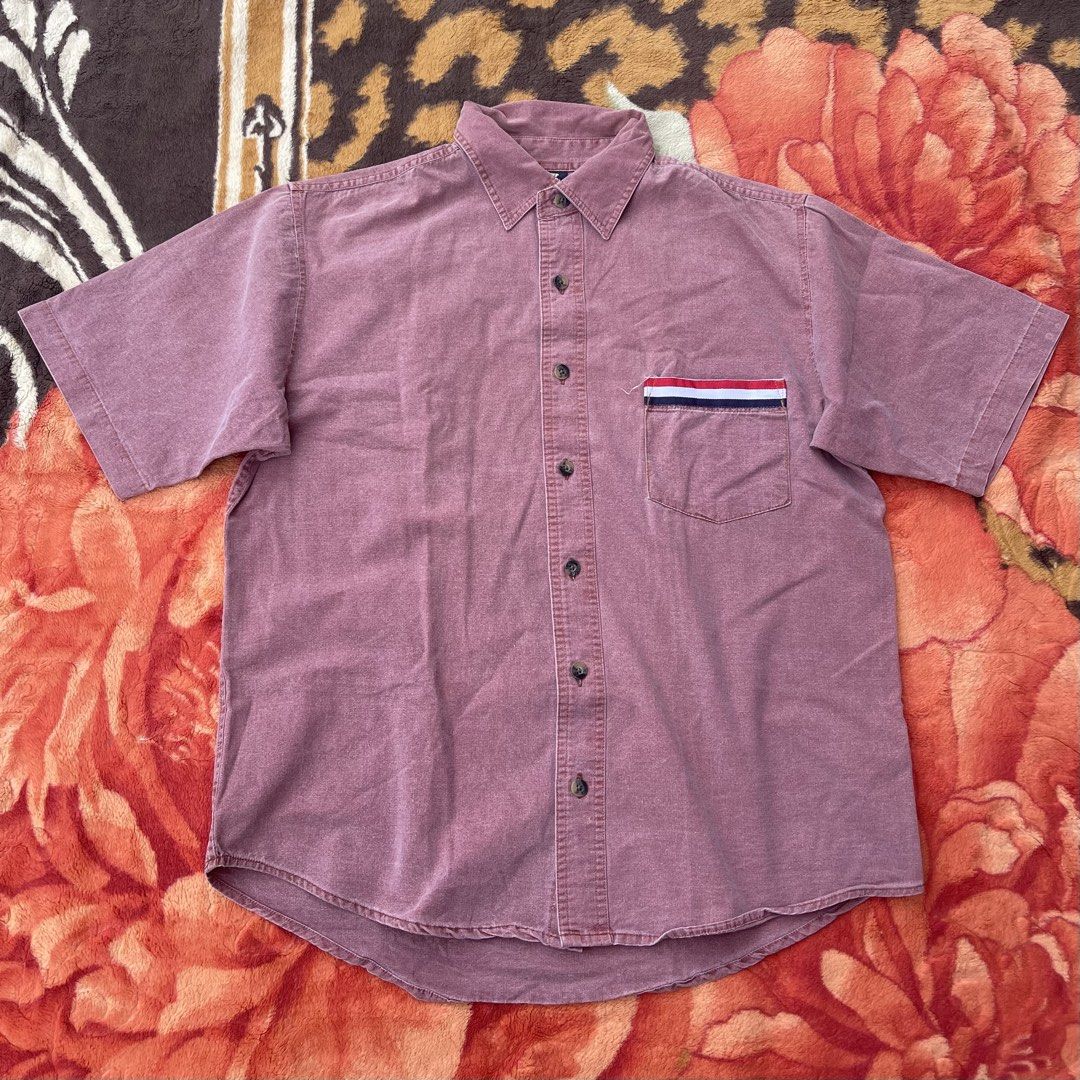 Tommy Hilfiger Short Sleeve Button Up Shirt (Category: Tshirts & Polo Shirts ) located in Manila. Submitted by aikyy_ (Listing ID 1460923093, Image 1). Description: - Classic Tommy Hilfiger short sleeve button up shirt - Features iconic red, white, and blue stripe detail on chest pocket - Color: Faded reddish-pink (vintage vibe) - Perfect for casual wear - Button-up front - Short sleeves.