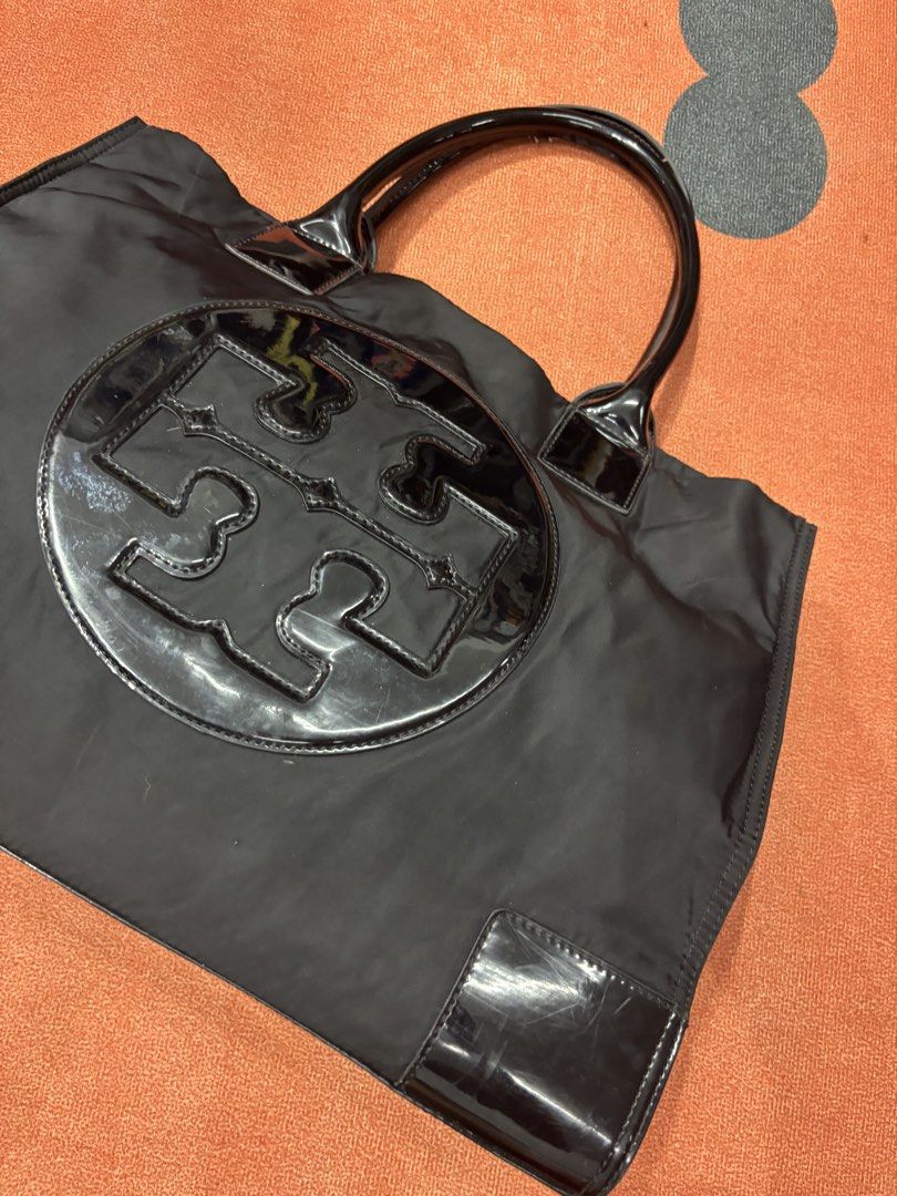 Tory Burch Black Nylon Tote Bag (Category: Luxury Bags & Wallets) located in Alicia. Submitted by thriftbagph (Listing ID 1461079816, Image 2). Description: - Authentic Tory Burch tote bag in classic black. - Durable nylon material with elegant patent leather accents. - Prominent large Tory Burch logo on the front. - Generously spacious interior for all your daily essentials. - Comfortable patent leather handles for easy carrying. - Ideal for eve