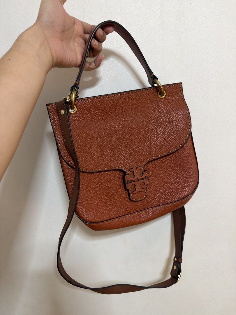 Tory Burch Brown Leather Shoulder Bag (Category: Luxury Bags & Wallets) located in Cavite. Submitted by misyelandco (Listing ID 1461107615, Image 1). Description: - Genuine brown pebbled leather shoulder bag - Signature Tory Burch logo clasp flap closure - Multiple interior compartments for organization - Adjustable shoulder strap for comfortable wear - Elegant stitching detail along the edges - Polished gold hardware accents.