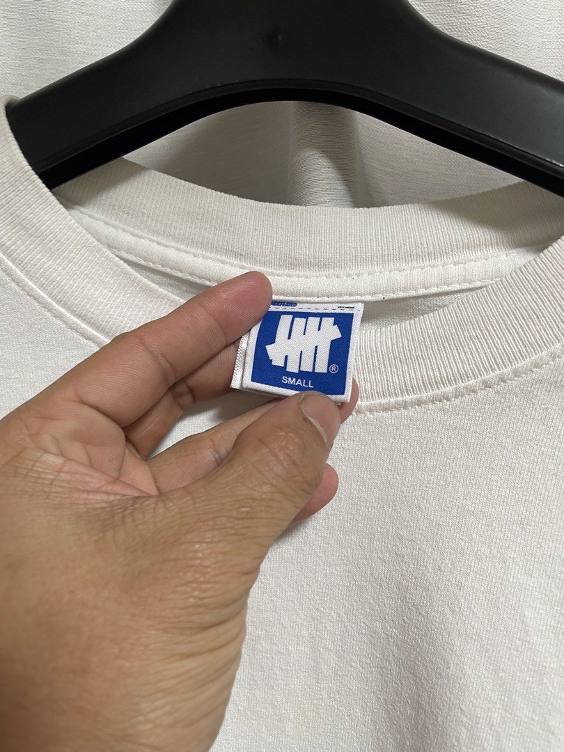 Undefeated White T-Shirt Size Small (Category: Tshirts & Polo Shirts ) located in Lapu Lapu. Submitted by mackoy221524 (Listing ID 1461088594, Image 2). Description: White short-sleeve tee from Undefeated. Features the classic Undefeated logo graphic on the front and back. Size Small. Good condition, some minor signs of wear on the graphic..