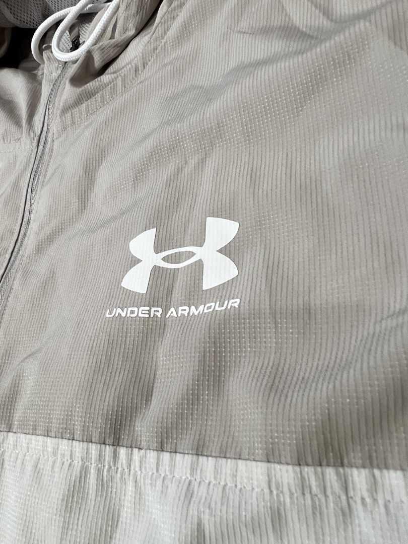 Under Armour Hooded Windbreaker Jacket Beige White (Category: Coats, Jackets and Outerwear) located in Manila. Submitted by flynnt2 (Listing ID 1461094026, Image 2). Description: UNDERAMOUR NO ISSUE LIKE NEW - Lightweight Under Armour jacket - Stylish colorblocked design (beige and white) - Features Under Armour logo on chest - Large logo graphic on the back - Hooded with adjustable drawstring - Elastic cuffs and hem for a snug fit - Ideal for ca